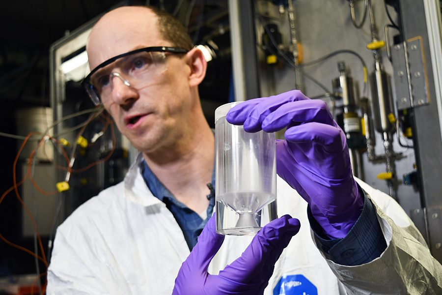Professor Tim Pourpoint holds a rocket combustion chamber made of clear sapphire