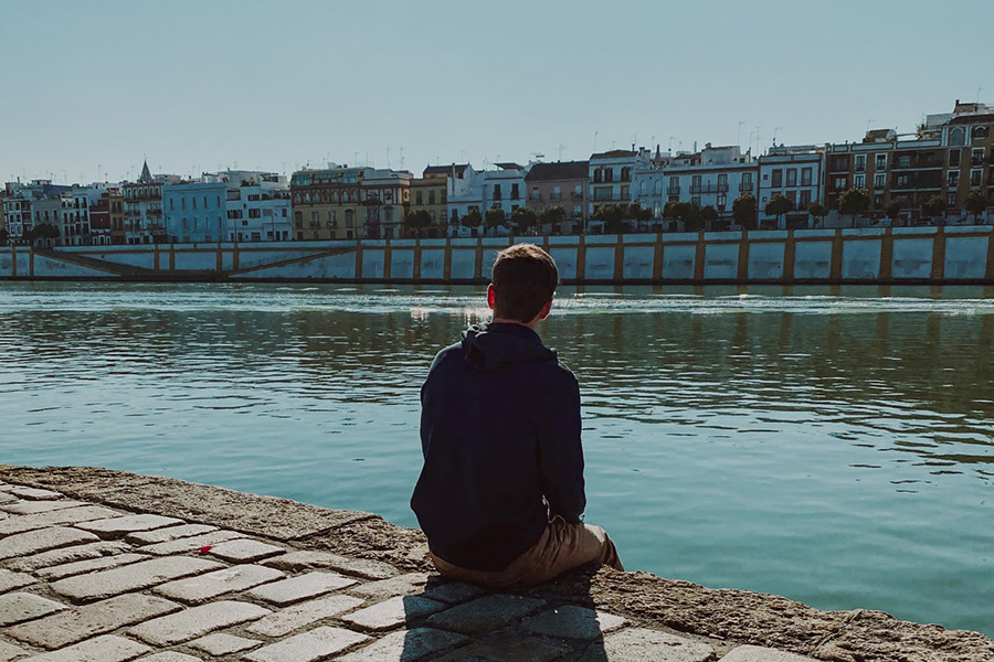 Robert sitting along the ro Guadalquivir in Seville, Spain