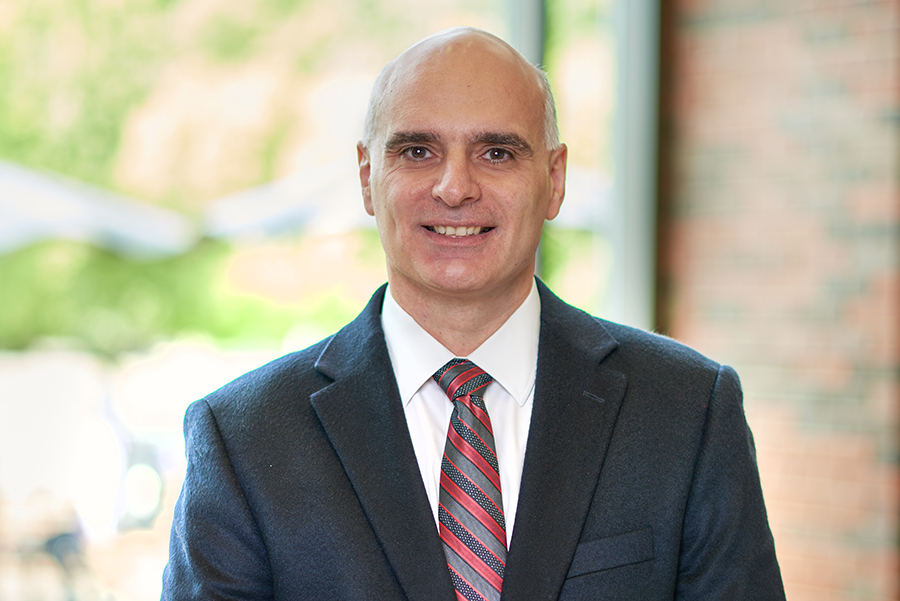 Photo of Dimitrios Peroulis. He is wearing a dark gray suit with a striped tie. The phone was taken in the atrium of MSEE.