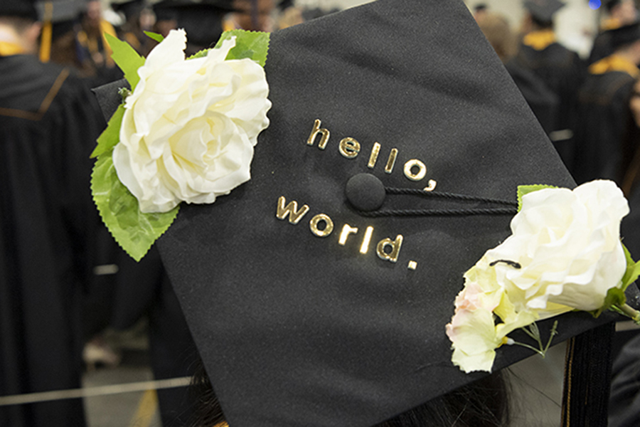 University stock photo of a student-decorated mortar board that reads 'hello world'.