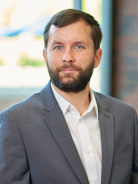 Portrait of Philip Pare. He is wearing a white button up shirt with a gray suit jacket.