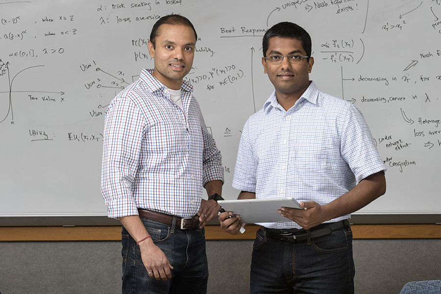 Two men stand side by side in front of a marker board. Ashish is on the right, and on the left is his PhD advisor, Professor Shreyas Sundaram.