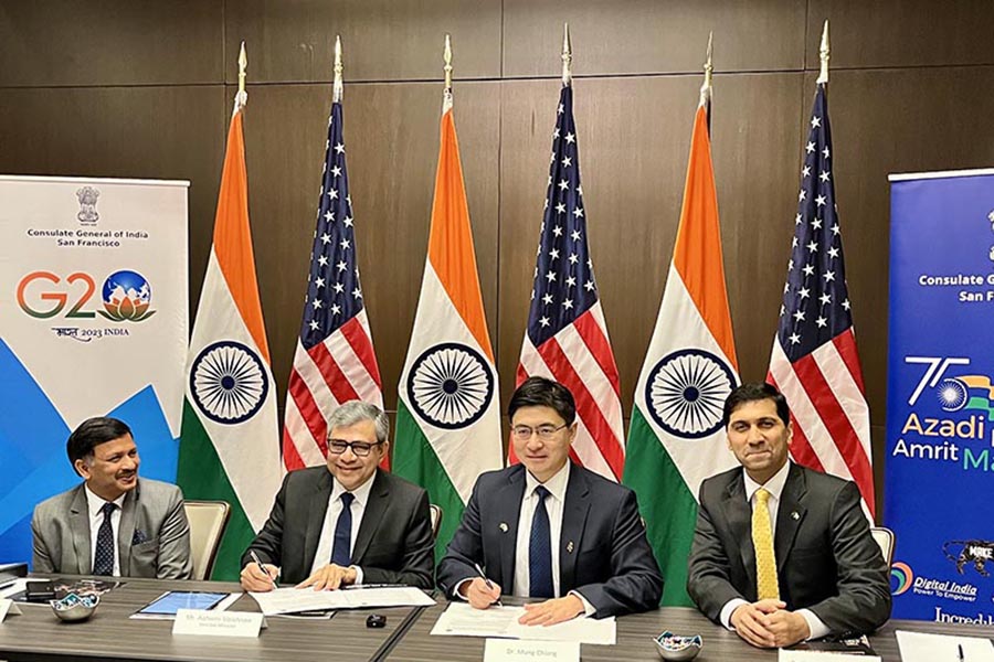 Nagendra Prasad, Consul General of the Indian Consulate in San Francisco; Honorable Ashwini Vaishnaw, India's Union Minister for Railways, Communications, Electronics and IT; Purdue President Mung Chiang; and Vijay Raghunathan, Purdue professor and Associate Head of Electrical and Computer Engineering and Director of Semiconductor Education for Purdue are seatied at a long table and facing the camera. Behind them are Indian and US flags.