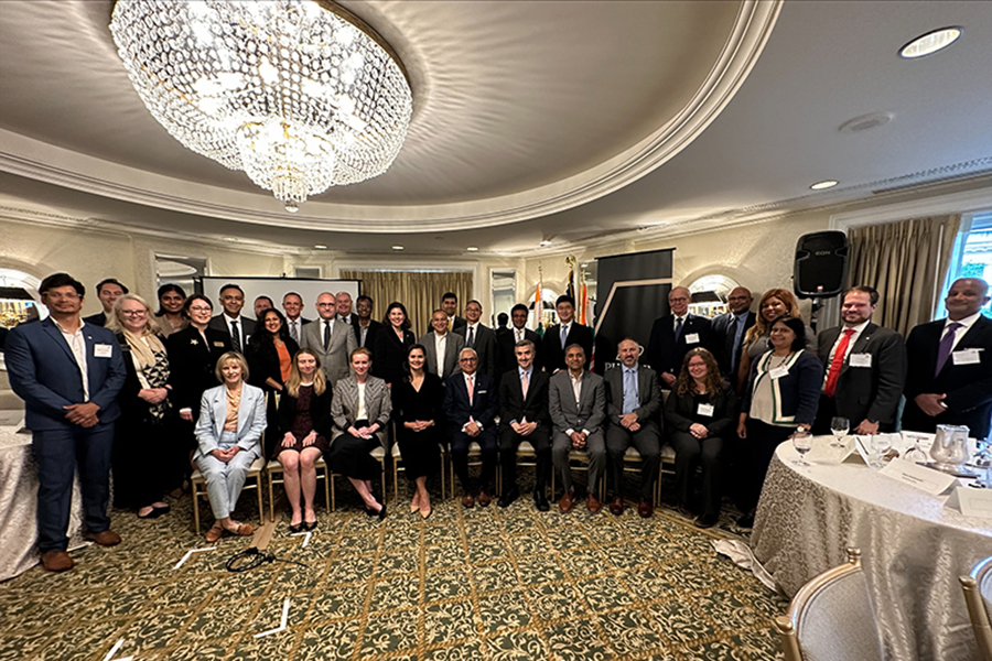 Photo of the participants of the USA-India Semiconductor Collaborative. They are gathered in a large room with a bright chandelier.