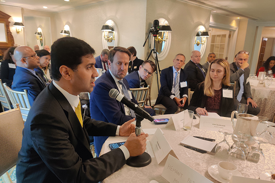 Professor Vijay Raghunathan speaks into a microphone at the gathering.