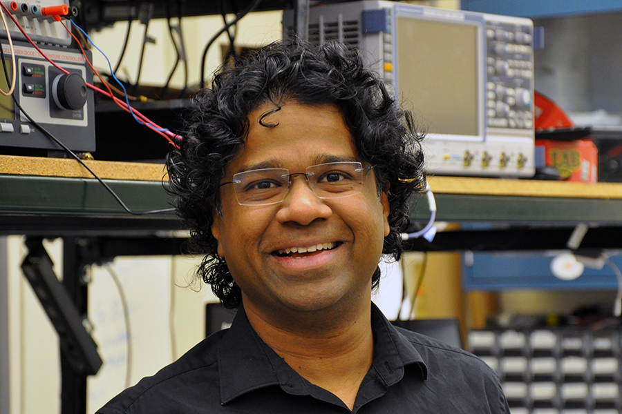 Professor Zubin Jacob stands in front of lab equipment.