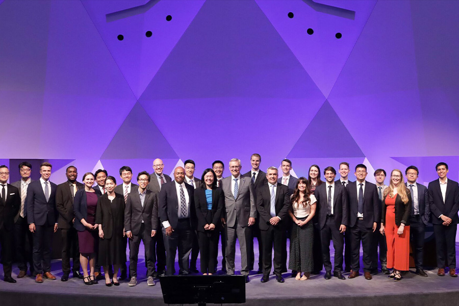 group of people in suits and ties standing on stage for a presentation
