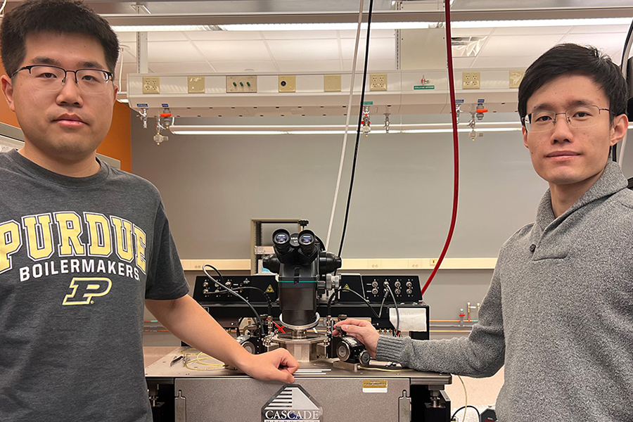 Purdue PhD students Chang Niu and Zehao Lin stand in front of lab equipment