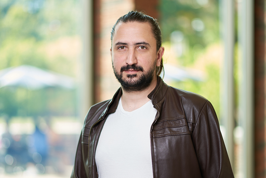Santiago Torres Arias poses for a portrait in the atrium of the MSEE building. He is wearing a white t shirt and a leather jacket.
