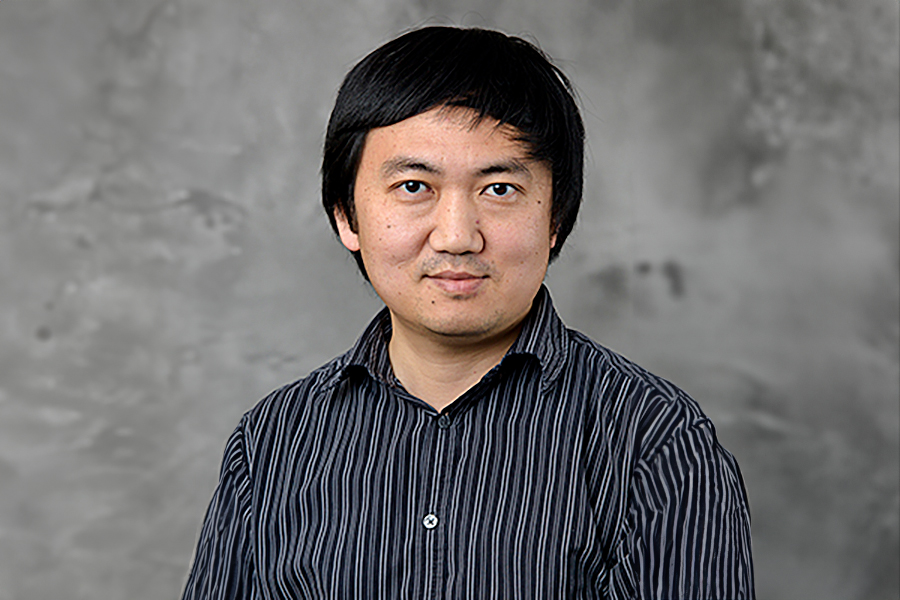 A man wearing a striped shirt poses confidently