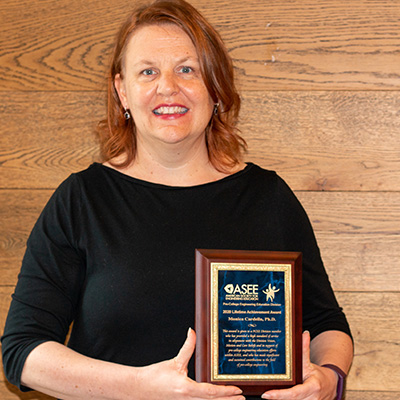 Dr. Cardella holding her Lifetime Achievement Plaque