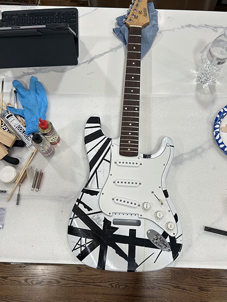 3D printed guitar, white background with black stripe elements