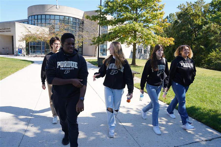 A group of students walking on Morgan State's campus, wearing Purdue sweatshirts