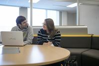 Graduate students discussing topic over a computer screen