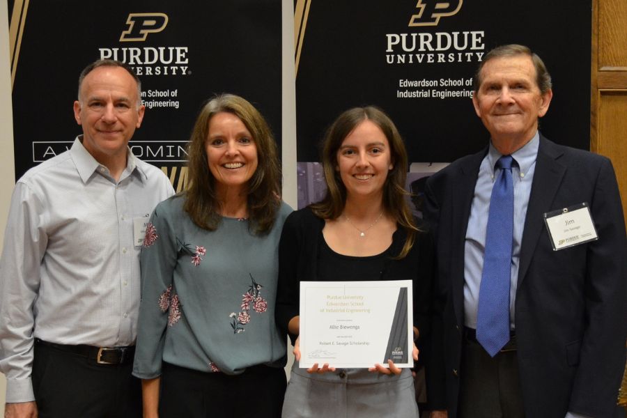 Allie Biewenga, Robert E. Savage Scholarship Recipient, poses for a photo with her family (left) and Jim Savage (right). Biewenga delivered an address to the attendees as part of the evening's events.